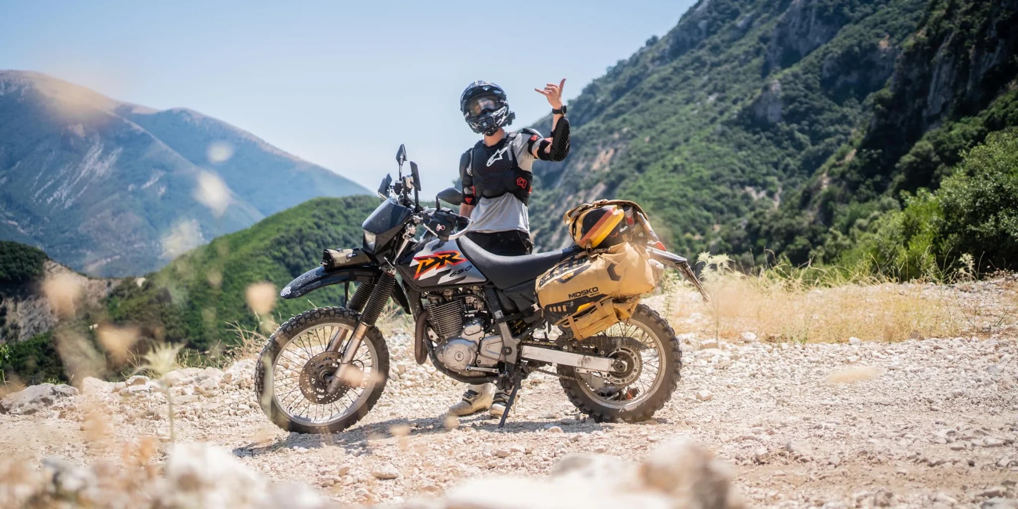 Motorcycle on a gravel plateau with mountains
